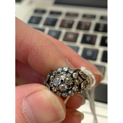 15 - A 19th century diamond cluster ring, the diamonds set in silver with a foliate engraved gold band an... 