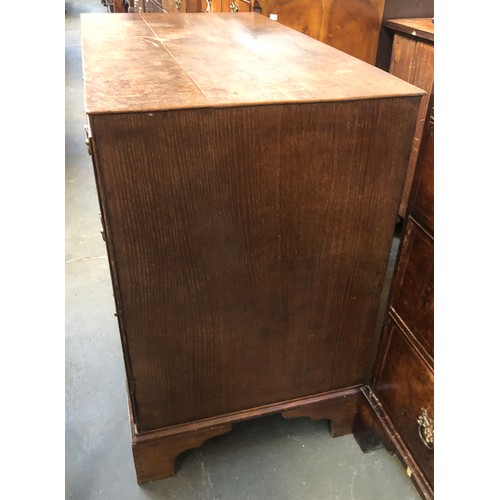 475 - An 18th century oak chest of three graduating drawers, the drawers surrounded by carcass mounted dou... 