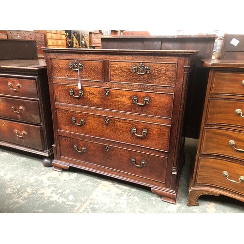 484 - A George III oak chest of drawers, the moulded top over two short and three graduating cockbeaded dr... 