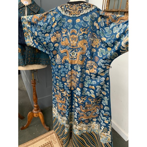 653 - A 19th century Chinese blue silk 'dragon' robe with long sleeves and horse hoof cuffs, detailed with... 