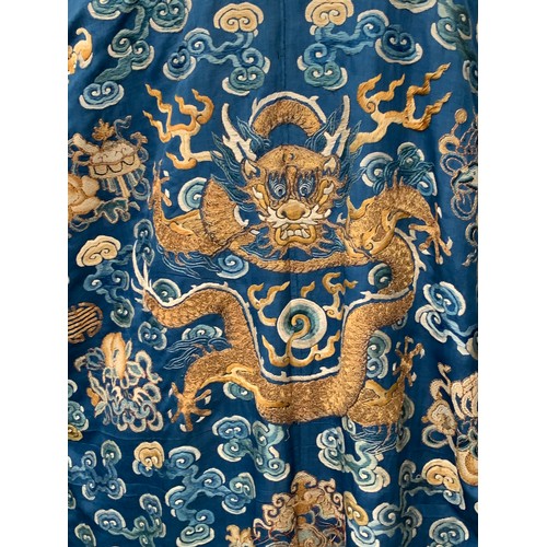 653 - A 19th century Chinese blue silk 'dragon' robe with long sleeves and horse hoof cuffs, detailed with... 