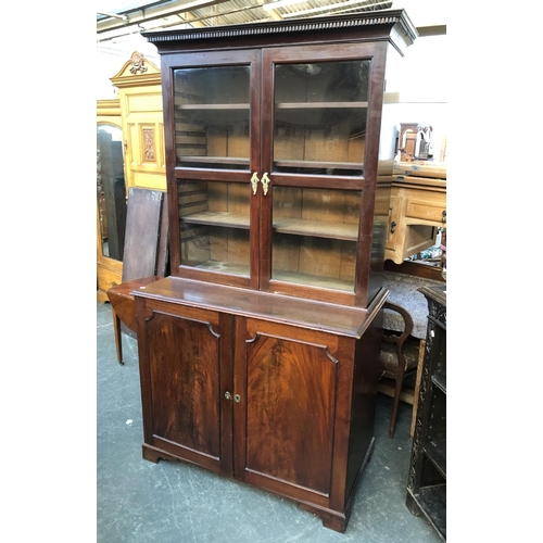 1057 - A George III mahogany library bookcase, dentil cornice over two glazed doors, opening to three adjus... 