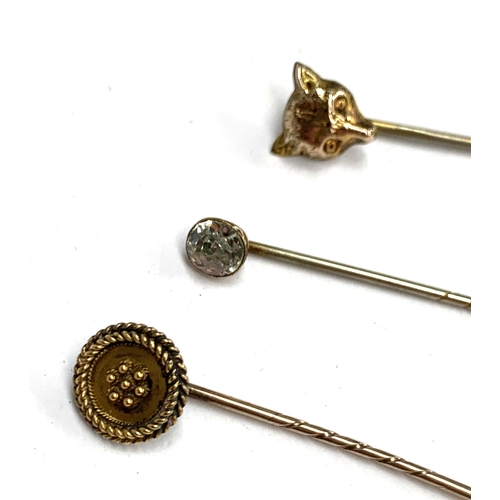 6 - A 15ct gold stick pin, 1.4g; together with a 9ct sovereign mount, 1.6g; a fox mask stick pin and one... 