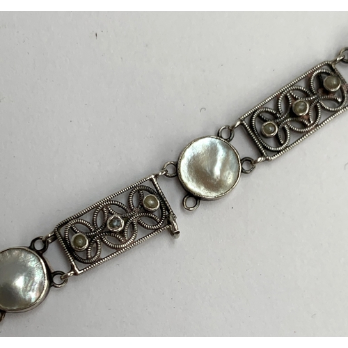 16 - A Scandinavian silver and pearl bracelet (in need of repair), openwork panels set with three seed pe... 