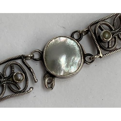 16 - A Scandinavian silver and pearl bracelet (in need of repair), openwork panels set with three seed pe... 