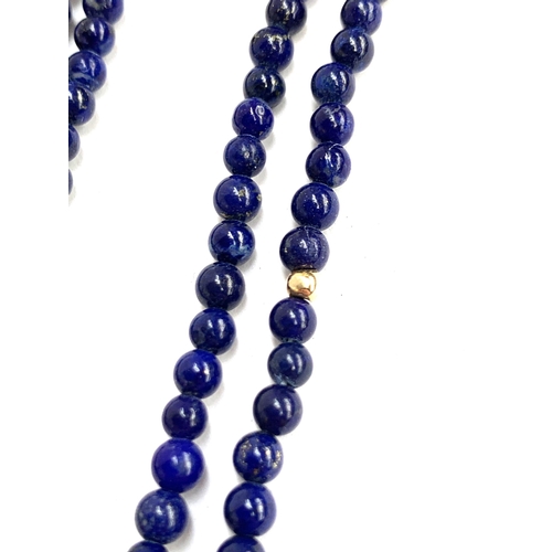 27 - A long lapis and gold (tests as 14ct or higher) bead necklace, the lapis beads approx. 3mm in diamet... 