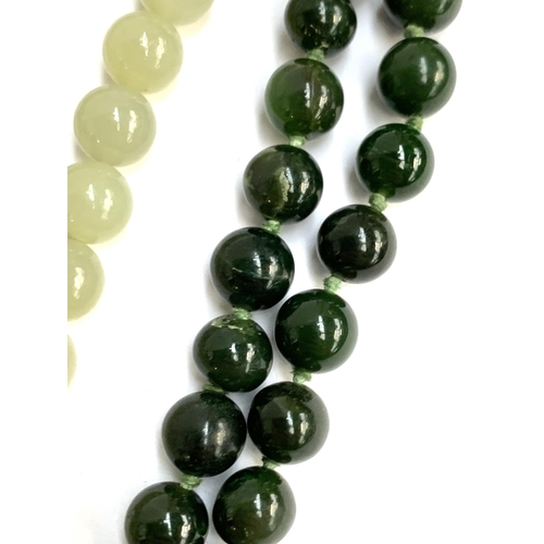 54 - A Chinese pale green jade bead necklace, each bead approx. 0.8cmD, overall 44.5cmL; together with on... 