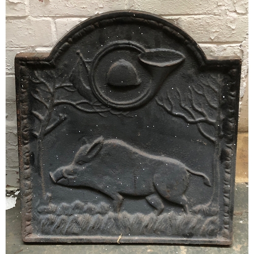 1043 - A French cast iron domed fire back, depicting a boar with hunting horn and cap above, 53x60cmH