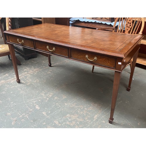 1016 - A 20th century writing table or bureau plat, good leather skiver, with three frieze drawers, veneere... 