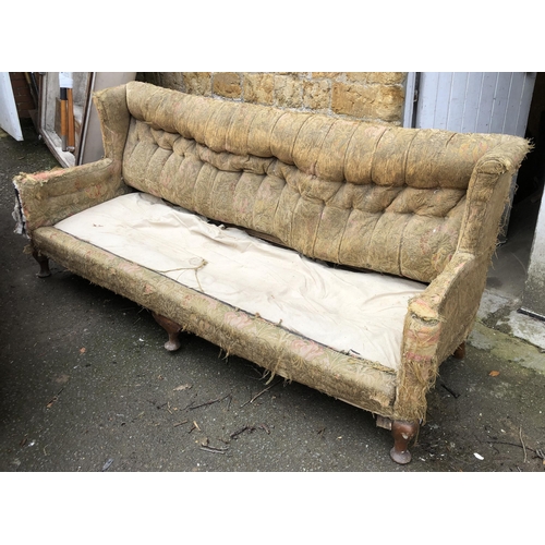 1018 - Upholstery project: a country house button back three seater sofa, in a state of disrepair, on sturd... 