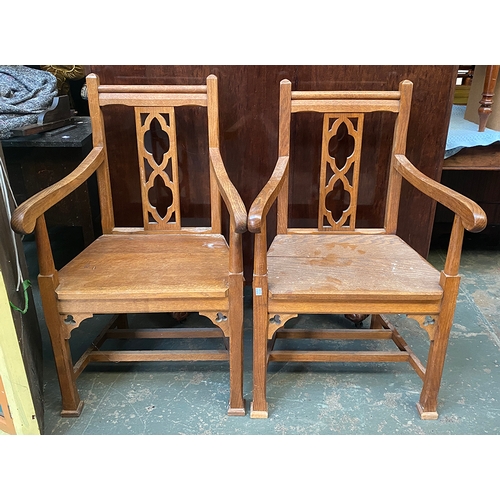 1026 - A pair of 20th century oak Cotswold style open armchairs