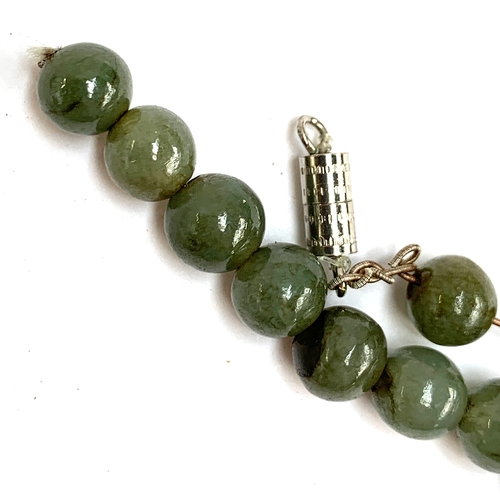 54A - A Chinese jade bead necklace, the beads approx. 0.7cmD, in need of restringing, with a white metal b... 