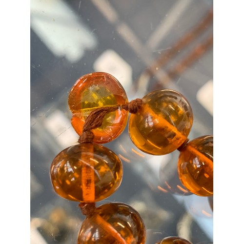 55 - A long string of amber beads, knotted, each bead approx. 1.4cmW, one bead cracked, approx. 95g, 50cm... 