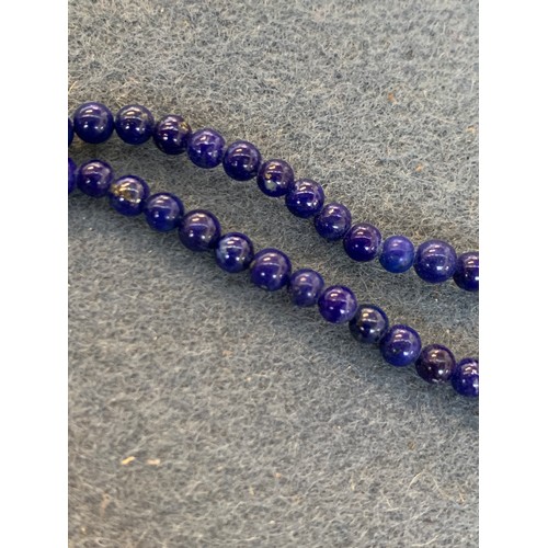 27 - A long lapis and gold (tests as 14ct or higher) bead necklace, the lapis beads approx. 3mm in diamet... 