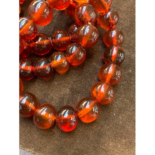 34 - A three row amber bead bracelet, with sliding clasp stamped 14/20, 58g