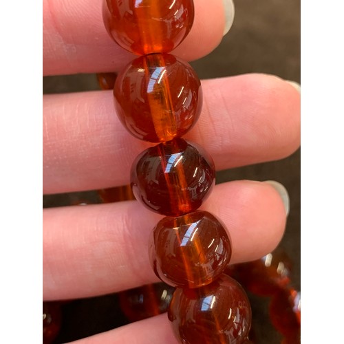 34 - A three row amber bead bracelet, with sliding clasp stamped 14/20, 58g