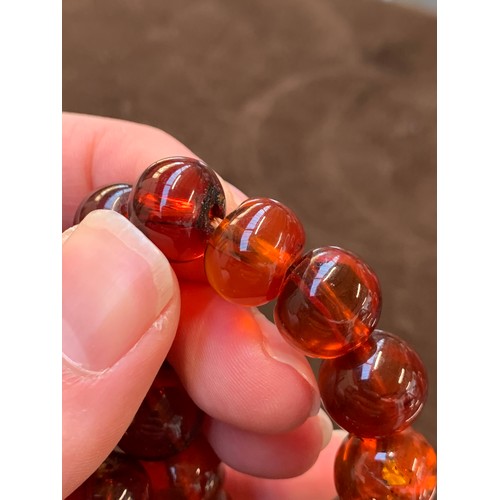 34 - A three row amber bead bracelet, with sliding clasp stamped 14/20, 58g