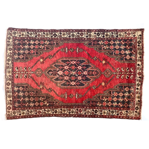 704 - A red ground Mazlaghan rug, central serrated lozenge, 190x124cm