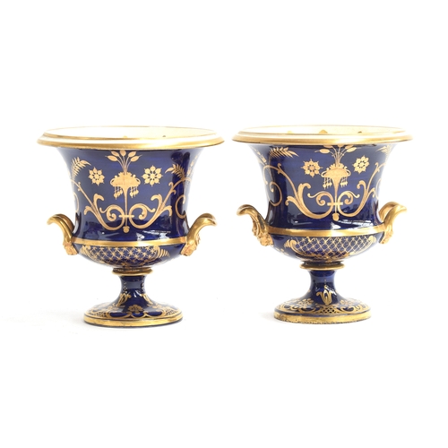 214 - A pair of 19th century twin handled porcelain urns, each with hand painted floral panel on a cobalt ... 