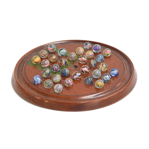 177 - A late 19th/early 20th century solitaire board with 32 mainly 19th century marbles with internal swi... 