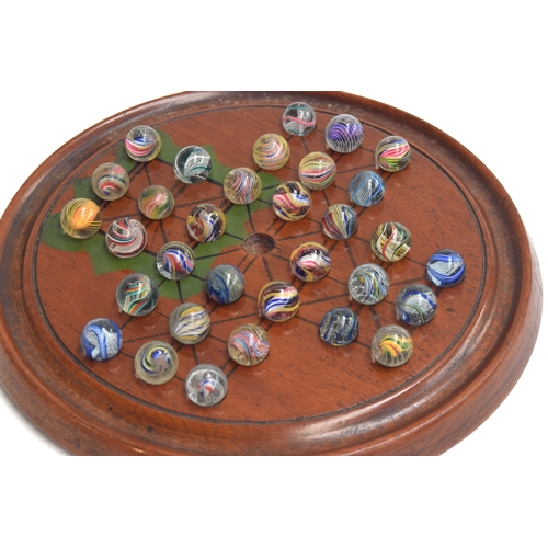 177 - A late 19th/early 20th century solitaire board with 32 mainly 19th century marbles with internal swi... 