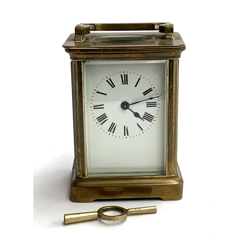 94 - A brass carriage clock with bevelled glass and enamel dial with Roman numerals, 11cmH, with key