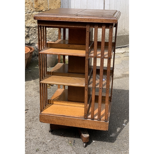 987 - An early 20th century oak rotating bookshelf, on ceramics casters, 50x50x90cmH