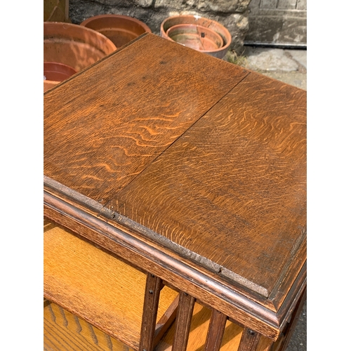 987 - An early 20th century oak rotating bookshelf, on ceramics casters, 50x50x90cmH