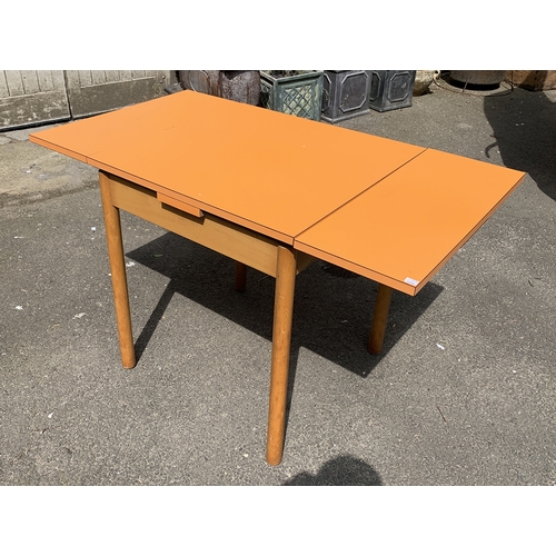 988 - A mid century orange formica topped extending kitchen table, 68x68x76cmH, each leaf an additional 26... 