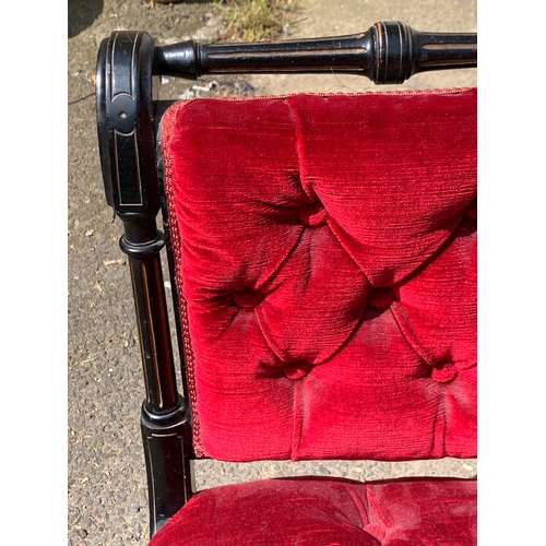 994 - An Aesthetic movement ebonised button upholstered slipper chair; together with a small footstool