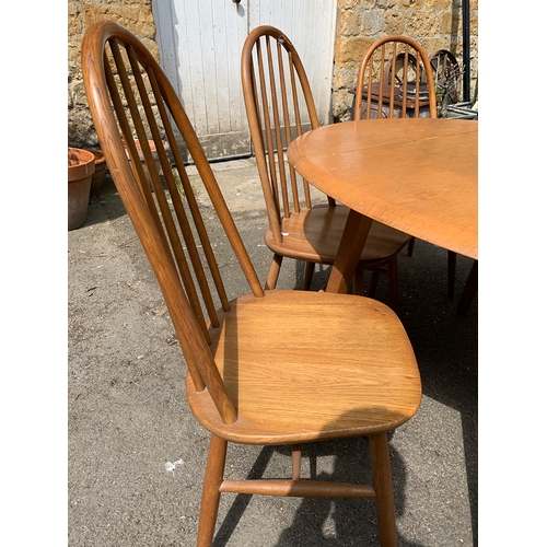 997 - A set of four beech and oak hoopback Ercol style kitchen chairs; together with a matching dropleaf t... 