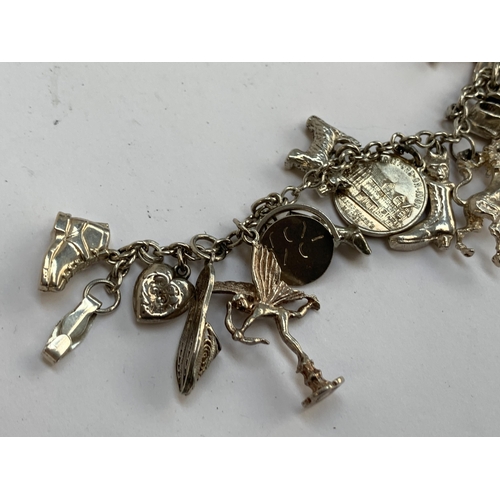 35 - A silver charm bracelet, approx. 23 charms, 53g