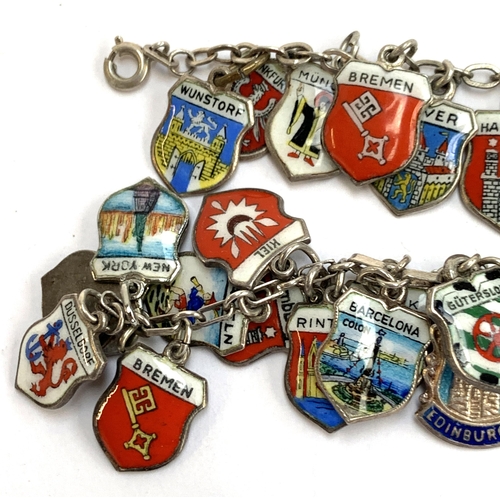 41 - Two silver charm bracelets with a large quantity of silver and enamel German and other flag and cres... 