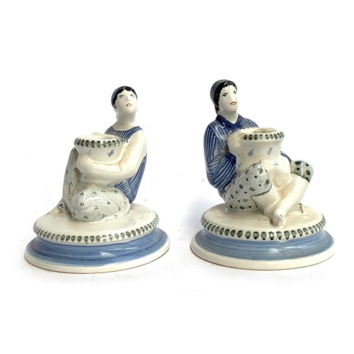 106 - A pair of Rye Pottery hand painted figural candlesticks in the form of a seated man and women in str... 