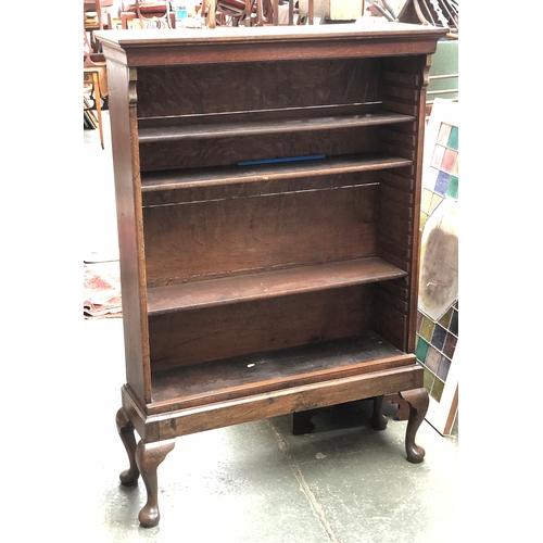 1036 - An oak bookcase, moulded cornice over adjustable shelves, on cabriole legs