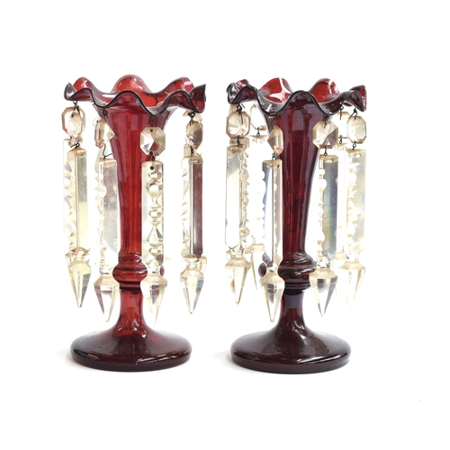 255 - A pair of 19th century cranberry glass table lustres, each with eight cut glass pendants, on tapered... 