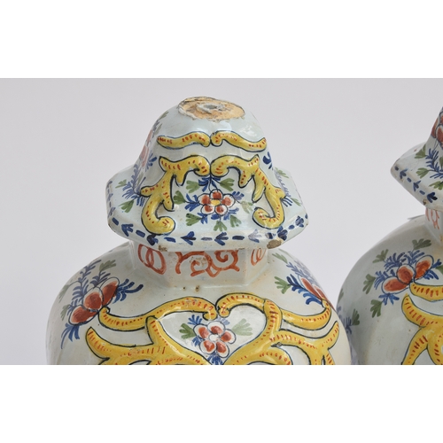 212 - A pair of late 18th century Delft polychrome vases and covers, each 35cm high, decorated with a cour... 