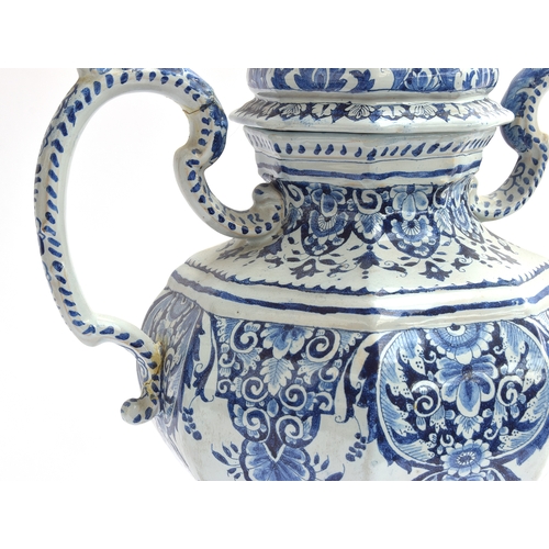 210 - An 18th century large Delft twin handled urn with cover, decorated with swirling florals, marked to ... 