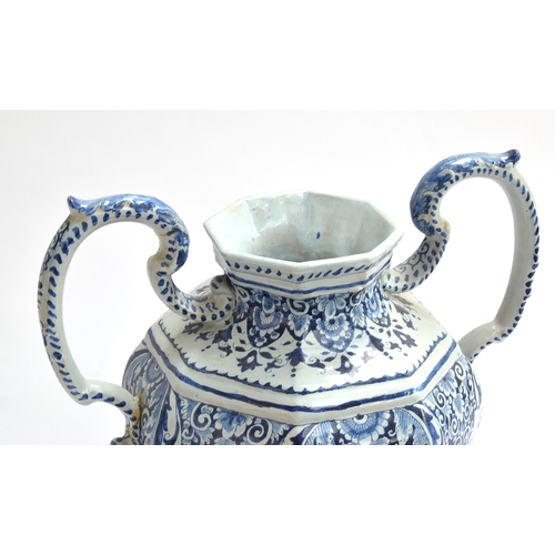 210 - An 18th century large Delft twin handled urn with cover, decorated with swirling florals, marked to ... 