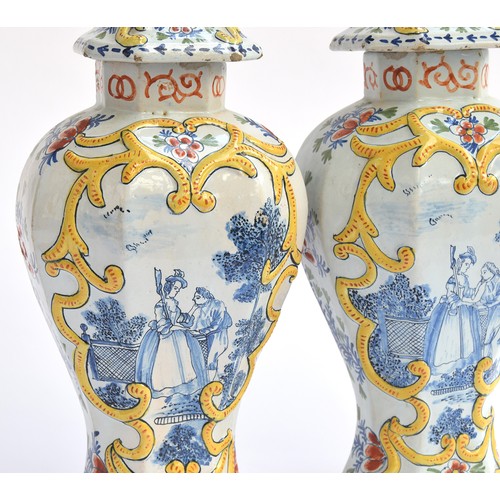 212 - A pair of late 18th century Delft polychrome vases and covers, each 35cm high, decorated with a cour... 