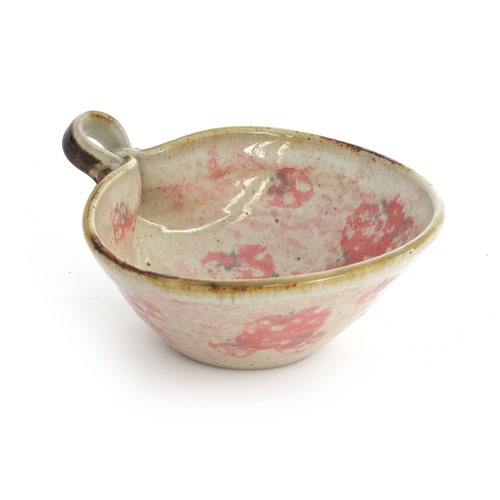 241 - Roger Cockram (b.1947) a studio pottery bowl with loop handle and strawberry design, 16.5cm wide