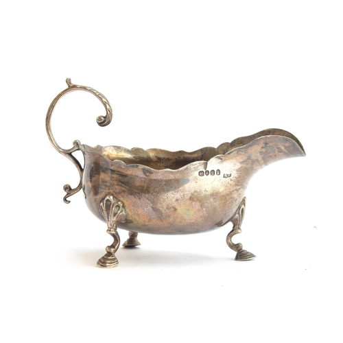 93 - A William IV silver sauce boat, London 1831, leaf capped handle and wavy edge, raised on three hoof ... 