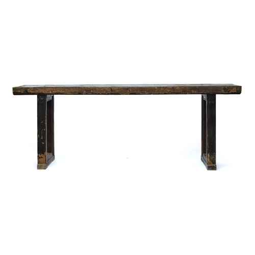 699 - A substantial Asian hardwood console table, two plank top on end supports, clad in a fibrous materia... 