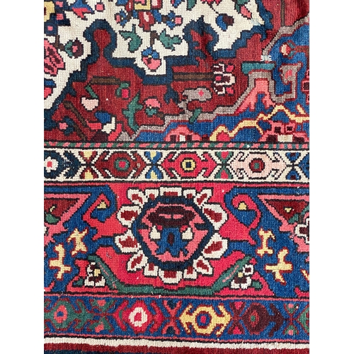 721 - A Persian Bakhtiar wool rug with central spandrel medallion, 290x210cm