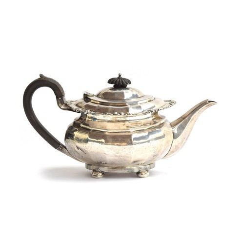 97 - An Edwardian silver teapot, Chester 1907, the rim chased with grape and vine, faceted body, on bun f... 