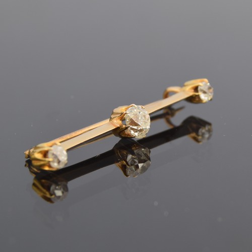 36 - An early 20th century gold and diamond bar brooch of knife edge form, the largest diamond approx. 0.... 