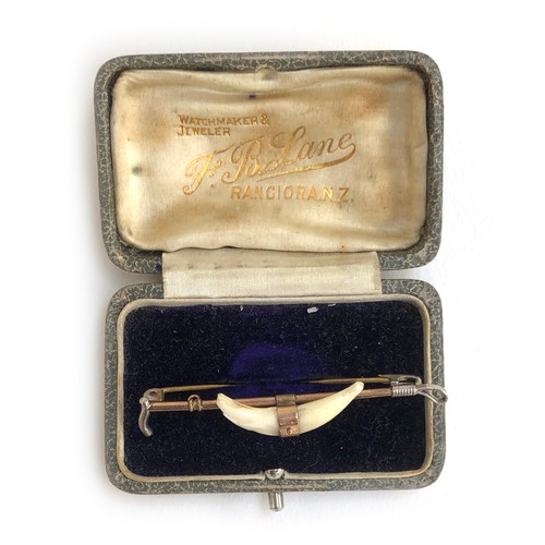 106 - An early 20th century 9ct gold and silver bar brooch in the form of a whip with mounted fox teeth, a... 