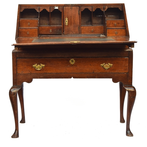 755 - An early 18th century oak bureau on stand, the fall front opening to a fitted interior with well, ov... 