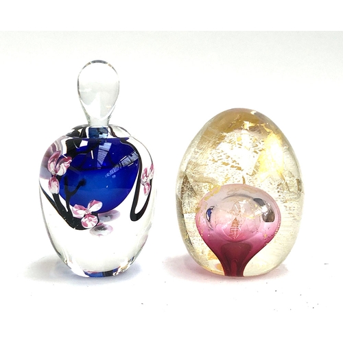 99 - A hand blown paperweight by Roger Gandelman, blue with pink flowers, signed and dated 1988; together... 