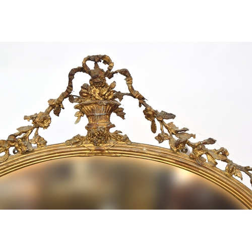 764 - A 19th century Italian gilt gesso oval mirror, with urn, ribbon and floral swag cresting, over a ree... 